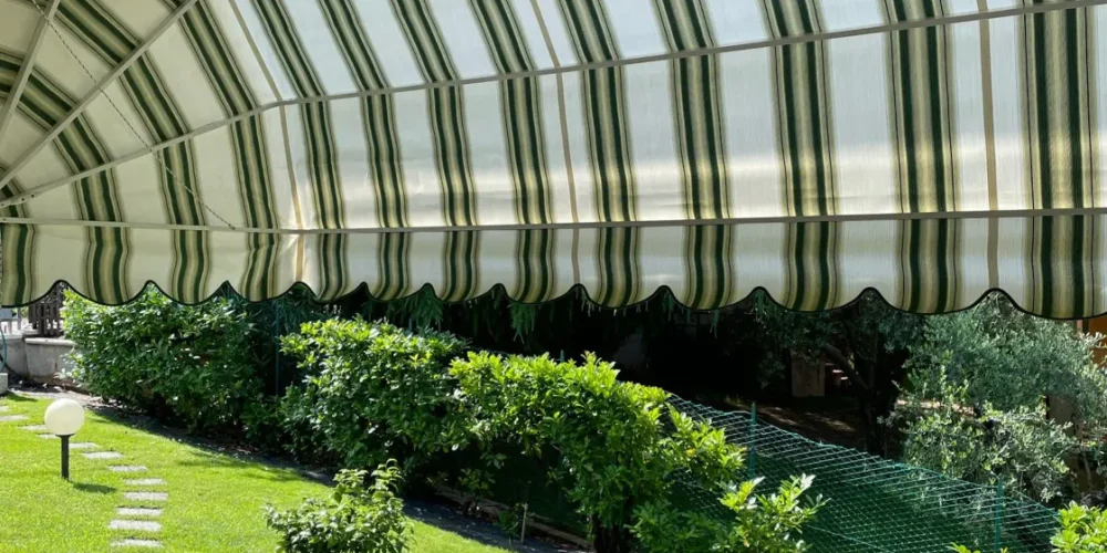 Tenda da sole verde e bianca installata da Massalongo Tendaggi